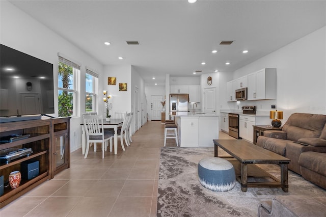 living room featuring light tile patterned floors, visible vents, and recessed lighting