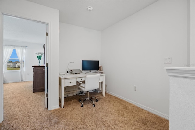 home office featuring light carpet and baseboards