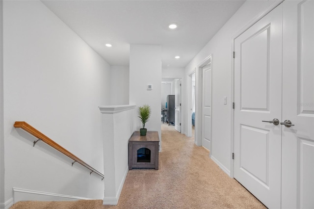 hall featuring recessed lighting, carpet, baseboards, and an upstairs landing