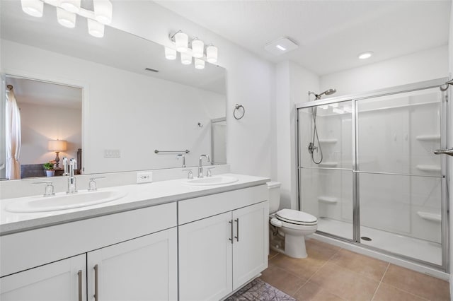 bathroom with a stall shower, a sink, toilet, and tile patterned floors