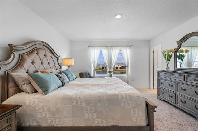 bedroom with a textured ceiling, carpet floors, and baseboards