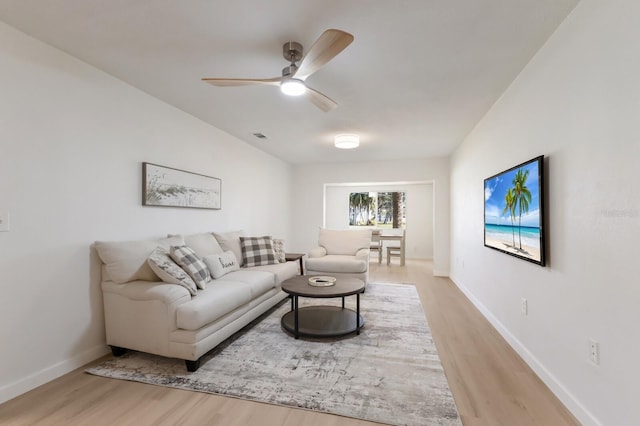 living area with a ceiling fan, visible vents, baseboards, and wood finished floors