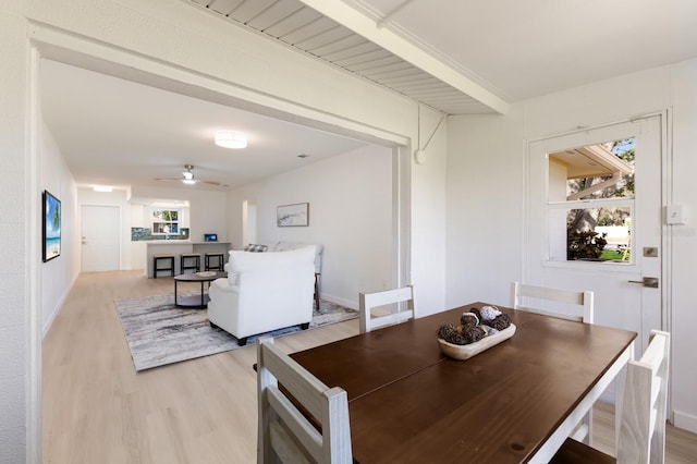 dining room featuring light wood-type flooring, a ceiling fan, and baseboards