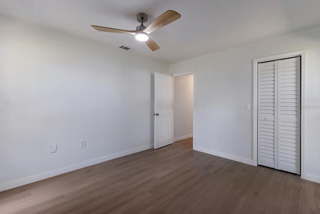 unfurnished bedroom featuring a ceiling fan, baseboards, visible vents, and wood finished floors