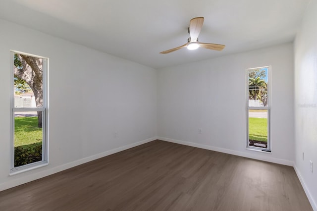 empty room with a ceiling fan, a healthy amount of sunlight, baseboards, and wood finished floors