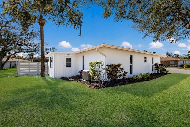 view of home's exterior featuring a yard, fence, and central AC unit