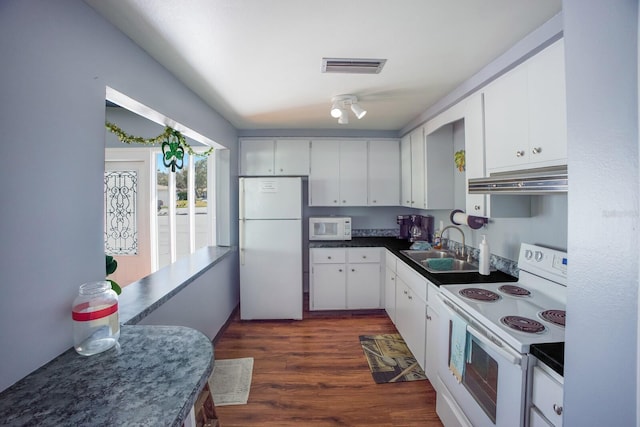 kitchen featuring under cabinet range hood, white appliances, dark wood-type flooring, a sink, and white cabinetry