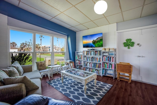 sitting room with a paneled ceiling and wood finished floors