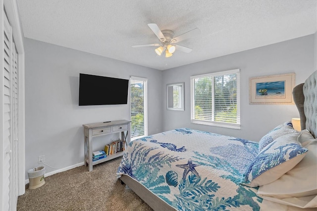 bedroom featuring a textured ceiling, ceiling fan, carpet, and baseboards