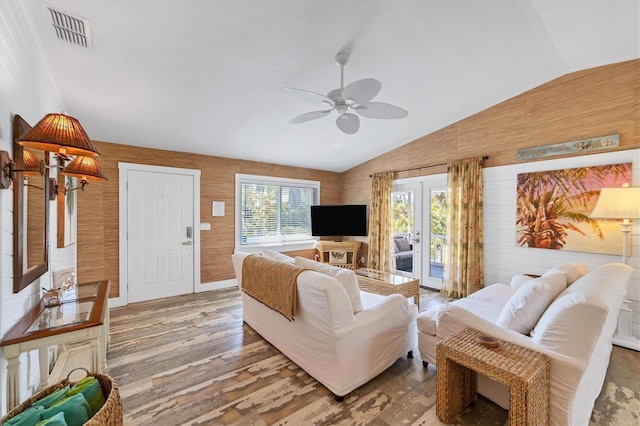 living area featuring lofted ceiling, ceiling fan, wood finished floors, visible vents, and french doors