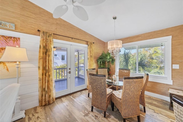 dining room with french doors, a healthy amount of sunlight, vaulted ceiling, and wood finished floors