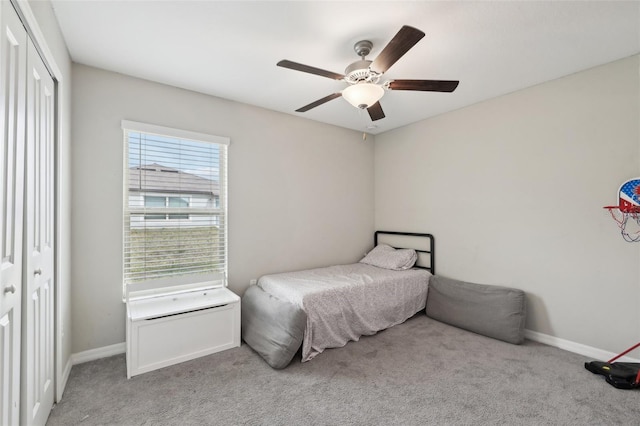 bedroom featuring baseboards, a closet, and light colored carpet