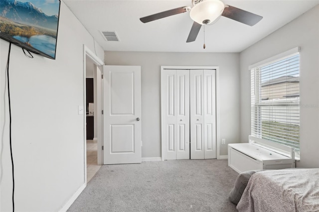 bedroom featuring a closet, light colored carpet, visible vents, ceiling fan, and baseboards