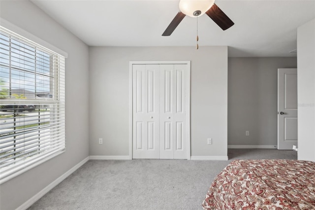 bedroom featuring ceiling fan, a closet, carpet, and baseboards