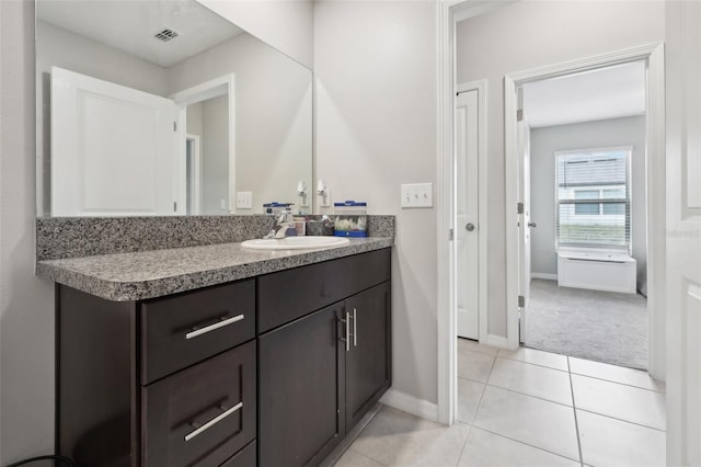 bathroom featuring visible vents, vanity, baseboards, and tile patterned floors