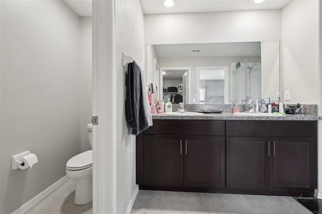 full bathroom with double vanity, a sink, toilet, and tile patterned floors