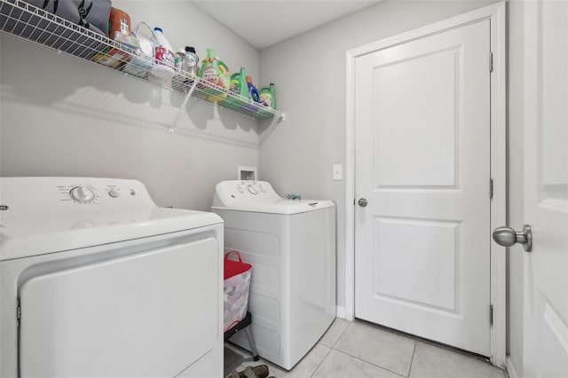 washroom featuring laundry area, light tile patterned floors, and separate washer and dryer