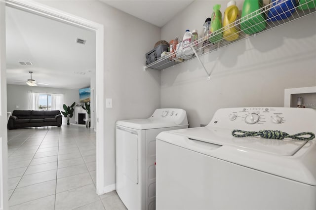 laundry room featuring light tile patterned floors, washing machine and dryer, laundry area, and visible vents