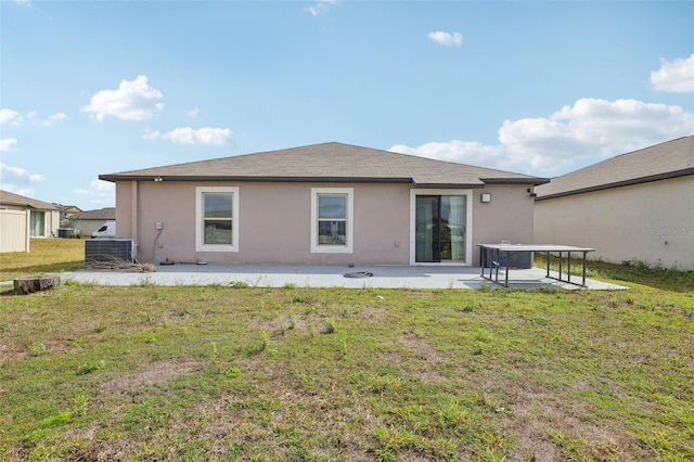 back of house featuring a patio, a lawn, and stucco siding