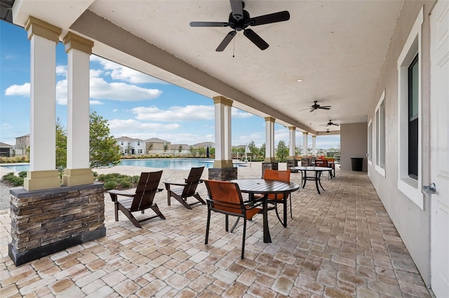 view of patio featuring ceiling fan, outdoor dining area, and an outdoor pool