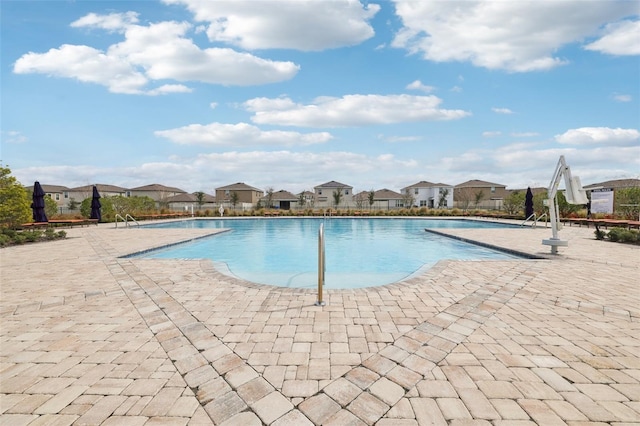 community pool with a patio area and a residential view