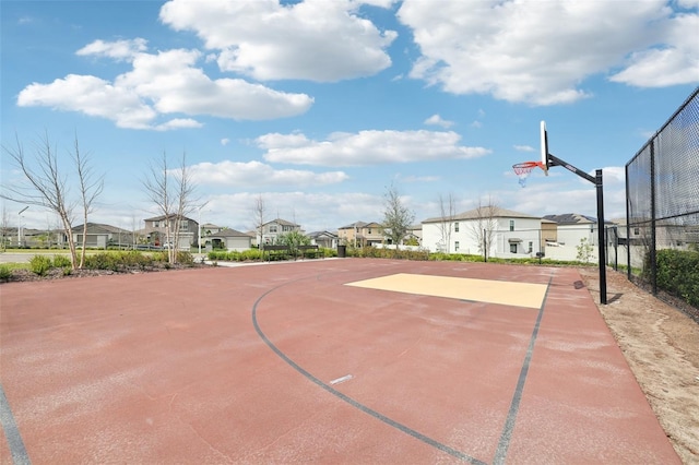 view of sport court with community basketball court, fence, and a residential view