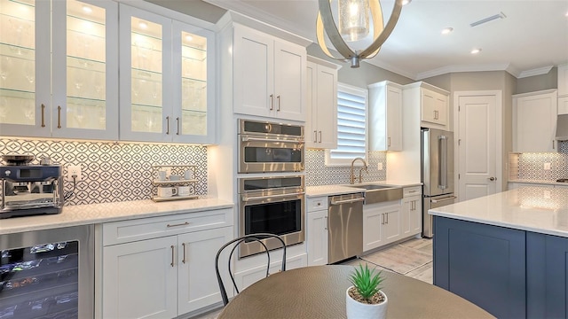 kitchen with visible vents, a sink, white cabinetry, wine cooler, and appliances with stainless steel finishes