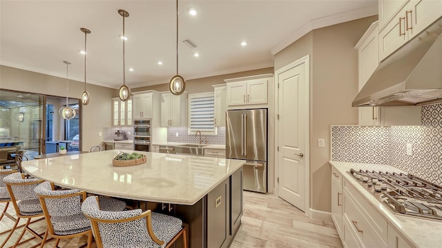 kitchen with visible vents, under cabinet range hood, a sink, white cabinetry, and appliances with stainless steel finishes