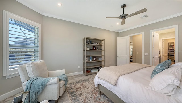 bedroom featuring visible vents, baseboards, light wood-style flooring, and crown molding