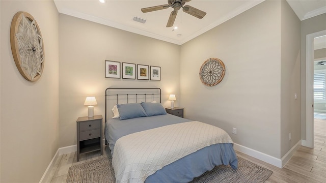 bedroom featuring light wood-type flooring, visible vents, baseboards, and ornamental molding