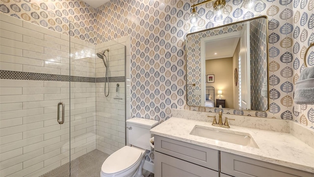 full bath with wallpapered walls, toilet, vanity, and a stall shower