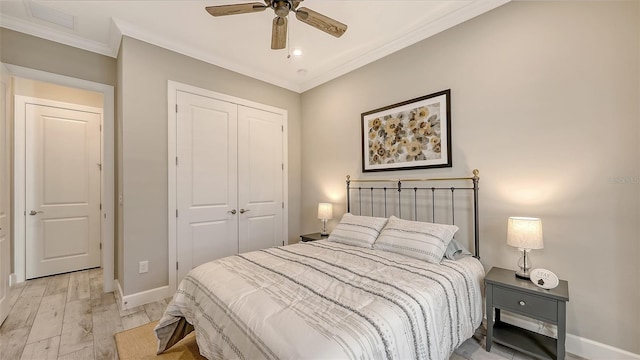 bedroom featuring light wood finished floors, ceiling fan, baseboards, ornamental molding, and a closet