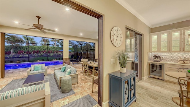 view of patio / terrace featuring wine cooler, glass enclosure, outdoor lounge area, an outdoor pool, and a ceiling fan