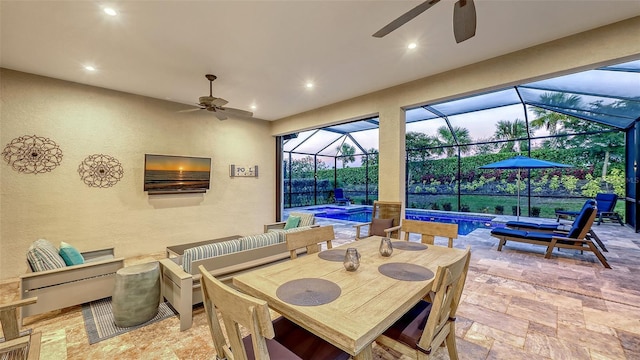 view of patio featuring outdoor dining space, a lanai, a ceiling fan, and an outdoor pool