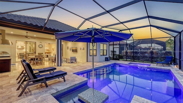 pool at dusk with an outdoor pool, exterior kitchen, a lanai, and a patio area