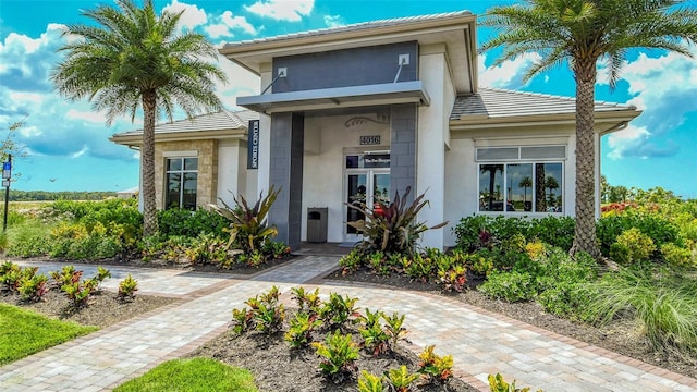 doorway to property featuring stucco siding and a tiled roof