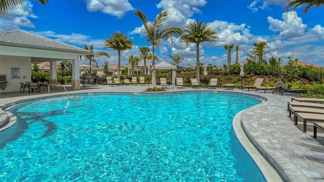 pool with a gazebo, a patio, and fence