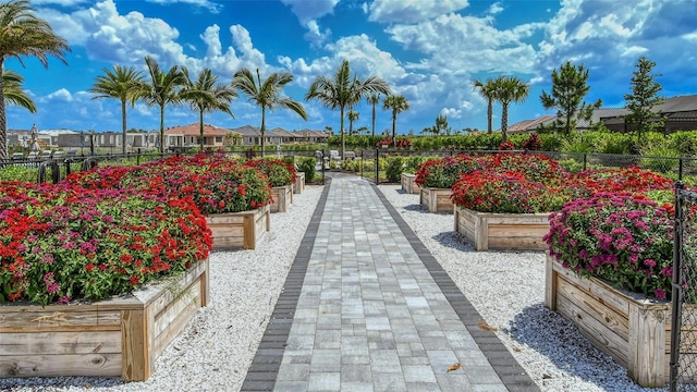 view of property's community with a residential view, fence, and a garden