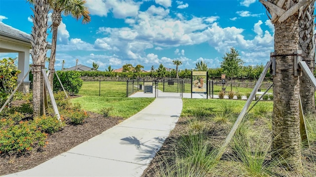 view of community featuring a gate, fence, and a yard