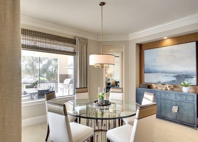 dining space with crown molding, light wood finished floors, and baseboards