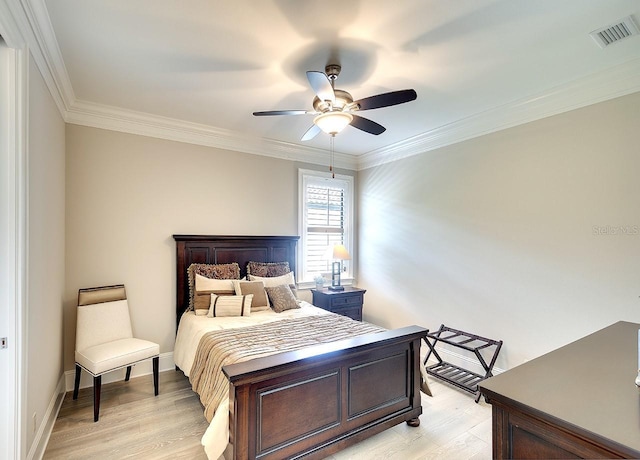 bedroom with crown molding, visible vents, light wood-style flooring, a ceiling fan, and baseboards