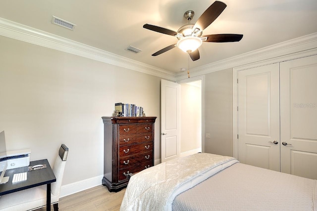 bedroom with light wood-style flooring, visible vents, baseboards, a closet, and crown molding