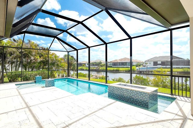 outdoor pool with a patio area, a lanai, a water view, and an in ground hot tub