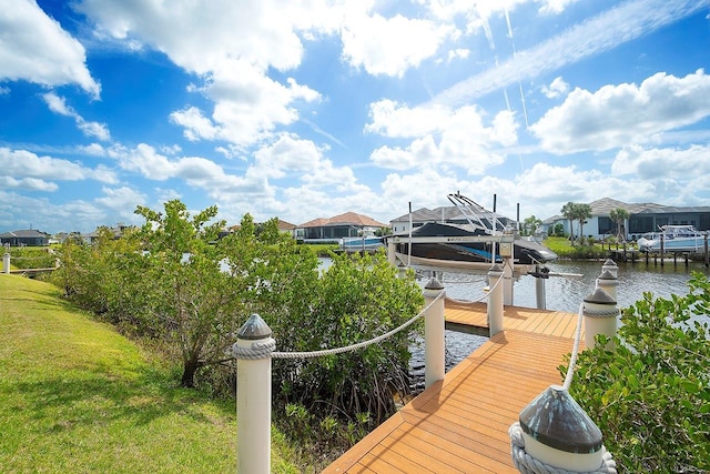 dock area featuring a residential view, a water view, a yard, and boat lift