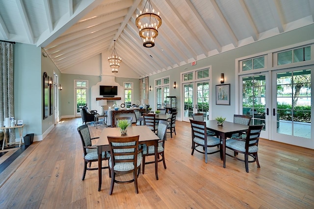 dining room featuring french doors, a notable chandelier, light wood-style flooring, high vaulted ceiling, and beamed ceiling