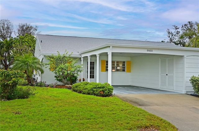 single story home with driveway, a carport, roof with shingles, and a front yard