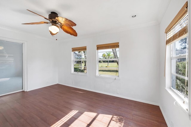 unfurnished room featuring ornamental molding, a ceiling fan, baseboards, and wood finished floors