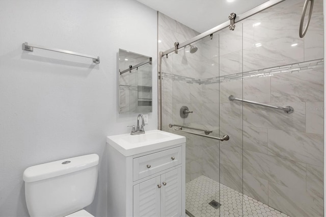 bathroom featuring toilet, a shower stall, and vanity