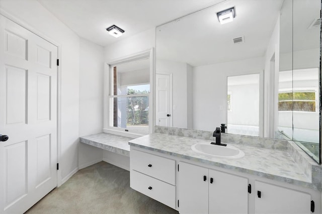 bathroom featuring visible vents, a healthy amount of sunlight, vanity, and baseboards