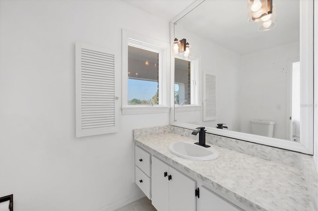 bathroom featuring toilet, baseboards, and vanity